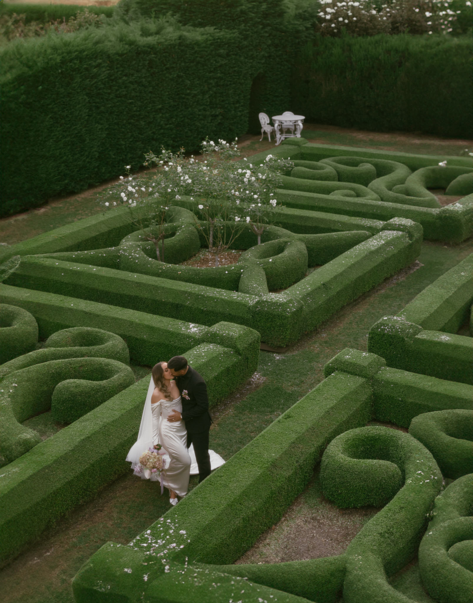 Bride & Groom kiss in the hedges photographed from above on their wedding day